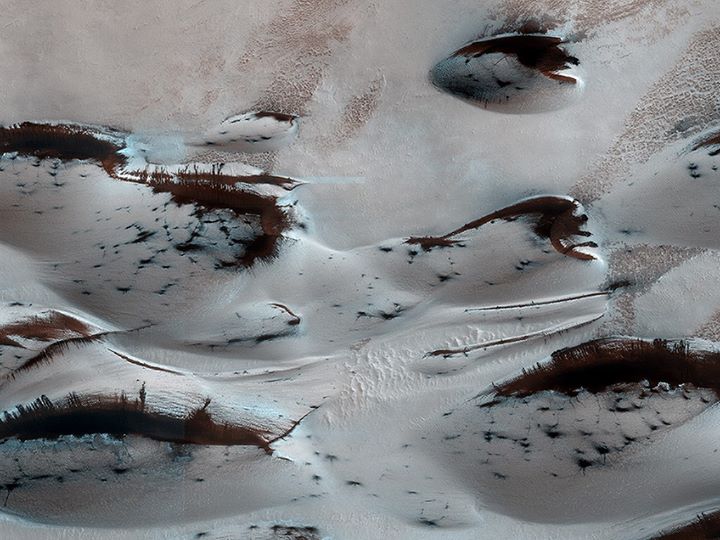 Carbon dioxide ice-covered dunes in the North Pole of Mars. the dark areas are locations where the ice has sublimated.